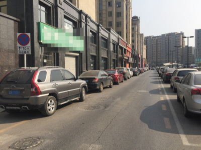 张前路乐购东侧一条单行道,一侧违停车辆无视路边的警示牌。