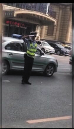 民警通过敬礼劝导违停车辆离开。