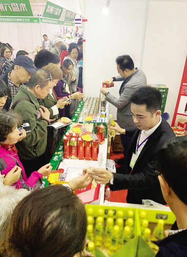市民争相品尝六盘水特产刺梨汁。