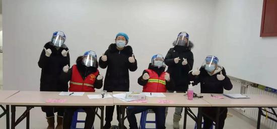 ▲王超(左三)和同事们一起投入到核酸检测采样登记工作中