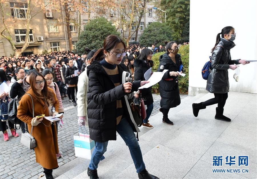 12月10日，在南京林业大学考点，考生进场参加考试。中央机关及其直属机构2018年度考试录用公务员的公共科目笔试在全国各考区统一举行。 2018年“国考”共有165.97万人通过了用人单位的资格审查，较去年增加了17.34万，通过资格审查人数与录用计划数之比为58：1。新华社记者孙参摄