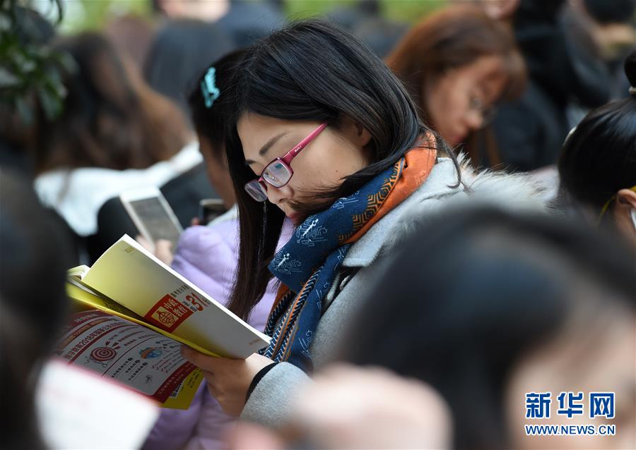 12月10日，在南京林业大学考点，考生在候考时复习。 2018年“国考”共有165.97万人通过了用人单位的资格审查，较去年增加了17.34万，通过资格审查人数与录用计划数之比为58：1。新华社记者孙参摄