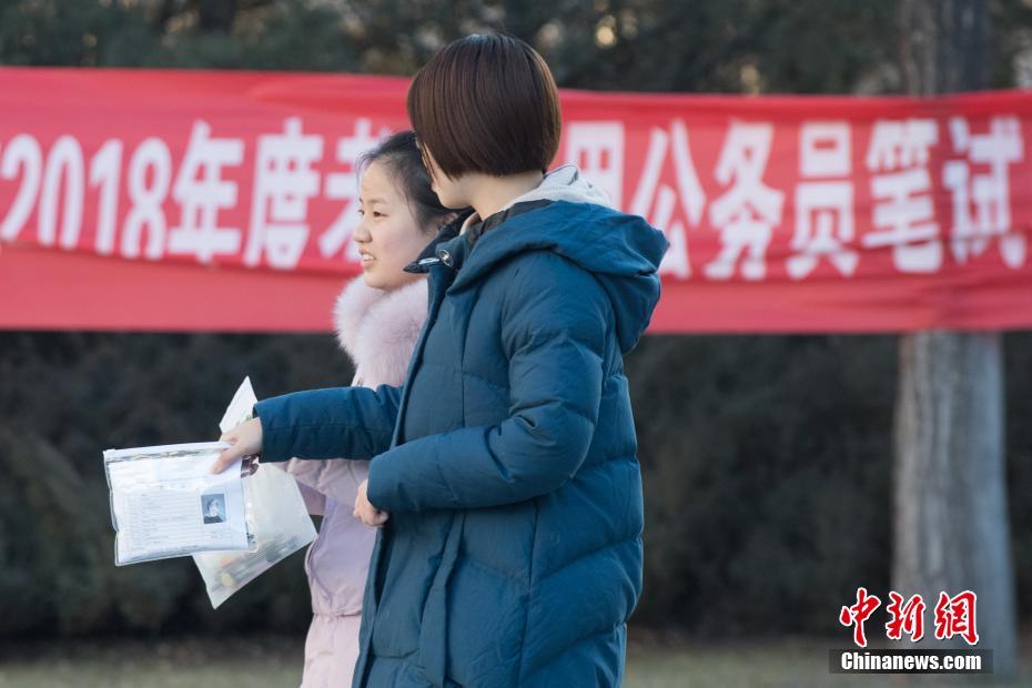 12月10日，山西太原一公务员考点，考生准备进入考场。当日，2018年度中央机关及其直属机构公务员招考笔试开考。本次国考计划招录2.8万余人，最终有165.97万人通过报名资格审查，较去年增加了17.34万，通过资格审查人数与录用计划数之比为58：1。 中新社记者 武俊杰 摄