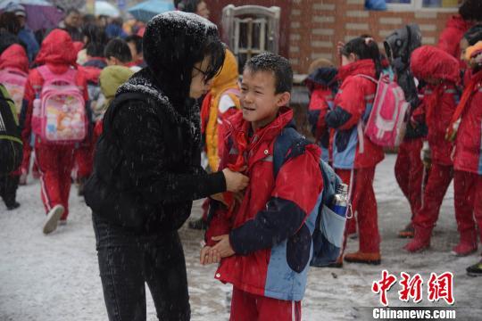 图为家长送孩子上学。　刘文华　摄