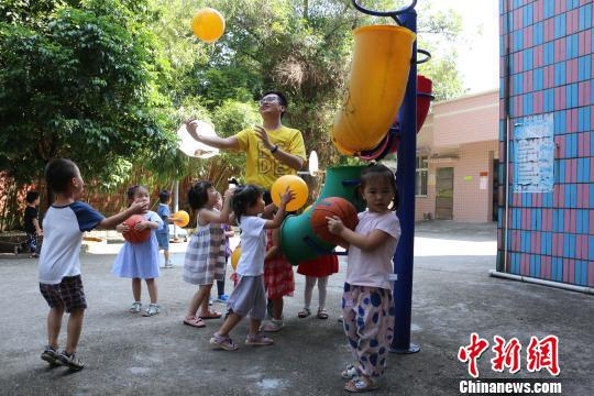  图为杨建琪陪幼儿园小孩子玩耍。　林馨 摄