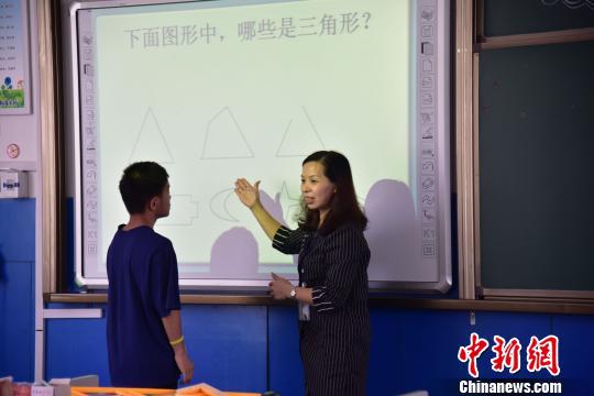 图为邱洪燕在引导学生答题。 王以照 摄 图为邱洪燕在引导学生答题。 王以照 摄