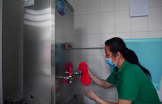 工作人员在对饮水设备进行消毒。新京报记者 李木易 摄
