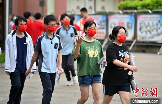 广西南宁考生佩戴印有“金莎总站唯一官网加油”字样的红色口罩走进考场。　俞靖 摄