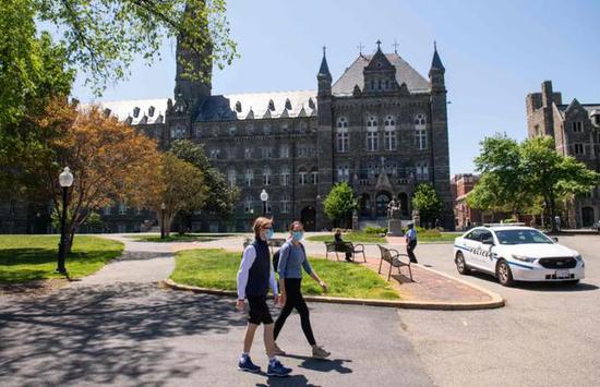  5月7日，在美国首都华盛顿，两名学生走在空旷的大学校园里。图/法新