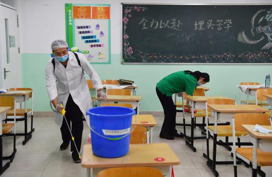 工作人员为教室进行消毒。新京报记者 李木易 摄