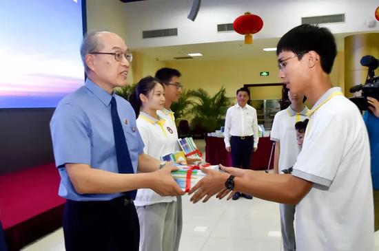 张军检察长向北京市第二中学赠送由检察机关组织编写的未成年人保护系列图书和普法系列图书。