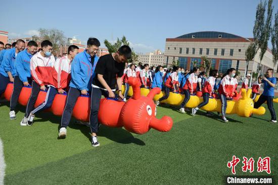 6月9日，高三学生参加毛毛虫竞速比赛，女生队与男生队齐头并进。　刘文华 摄