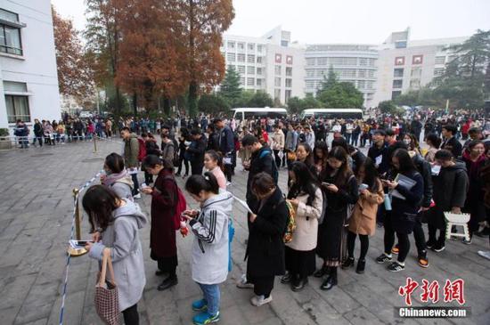 资料图:图为2018年12月2日,考生在2019国考南京林业大学考点等候进场参加考试。 中新社发 苏阳 摄 图片来源:CNSPHOTO