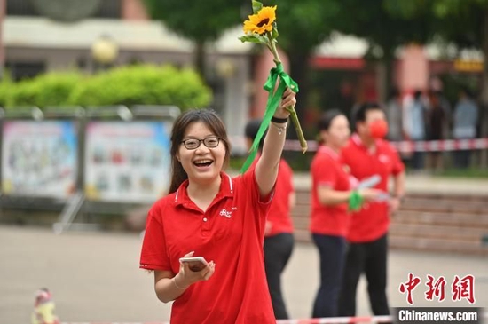 一名老师手持葵花为高考学子送祝福,盼学子一举夺魁。 俞靖 摄