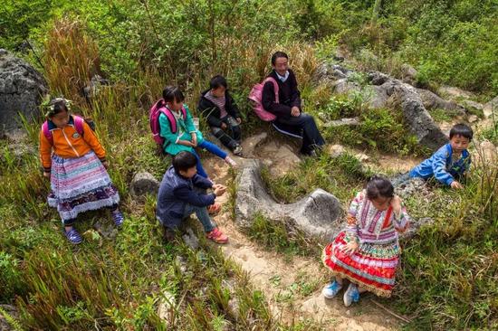 爬到崖顶上后师生精疲力尽休息一下