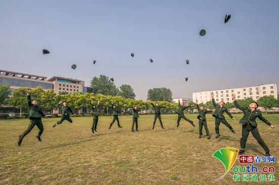 在希望的“田野”上，毕业学员奋力一跃，把军帽抛向天空，象征着毕业是一个从头开始，也是满怀希望、建功立业的起点。中国青年网通讯员 褚龙 摄