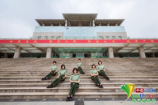  女学员们端坐在主教学楼石阶上，背后是习近平总书记提出的“对党忠诚、服务人民、执法公正、纪律严明”的十六字总要求，体现军校女学员的端庄、知性，矢志不渝。中国青年网通讯员 褚龙 摄