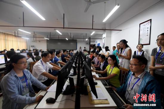6月15日，位于广西南宁的广西经济干部学院高考评卷点内，工作人员在电脑前阅卷。中新社记者 俞靖 摄