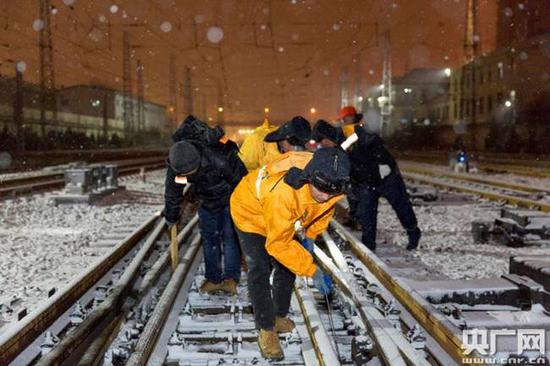 铁路维护人员冒雪清理轨道积雪（央广网发 中国铁路济南局供图）