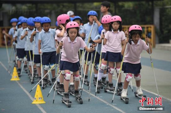 资料图:北京市中关村第三小学的学生们在校园内体验旱地越野滑雪。 中新社记者 崔楠 摄
