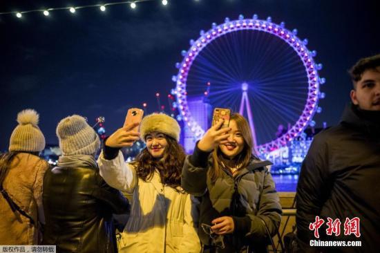 资料图:2017年12月31日,民众聚集在在英国伦敦眼前迎接新年到来。