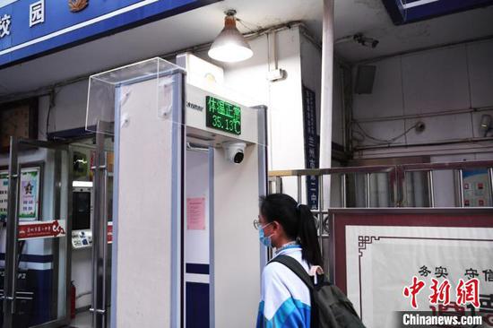 4月9日,甘肃18.2万名普通高中高三年级学生、近5万名中职学校毕业年级学生正式开始新的学期。图为兰州二中学生进校园测量体温。 杨艳敏 摄