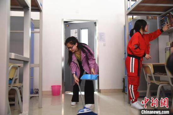 图为返校学生打扫宿舍。 张玮 摄