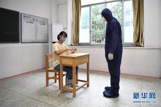 7月3日,工作人员(右)模拟为发热考生安排考试座位。 新华社记者 薛宇舸 摄
