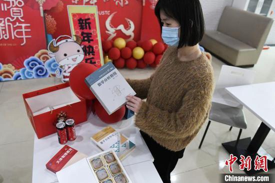 工作人员在展示被网友戏称“吃了不挂科”的中国科学技术大学“网红书型伴手礼”,最火爆的时候,预订后要等几个月才能拿到。今年留校过年的学生不用等了,新年大礼包里一定有一本。 张娅子 摄