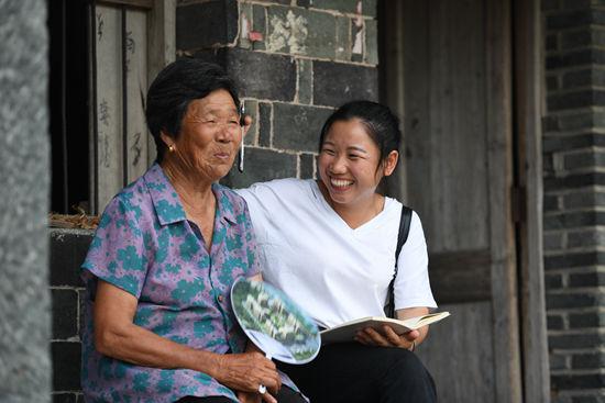 李美丽（右）在龙头湾村过溪自然村了解村民王春花的生活情况（7月26日摄）。