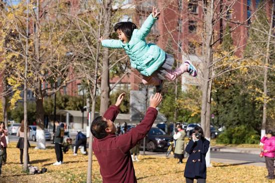 “来，飞高高！”西风把孩子举高