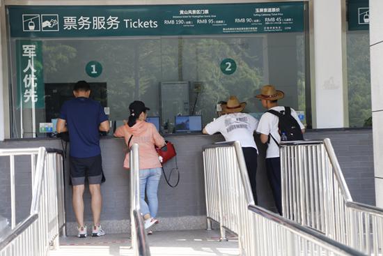 游客在黄山风景区售票处咨询。
