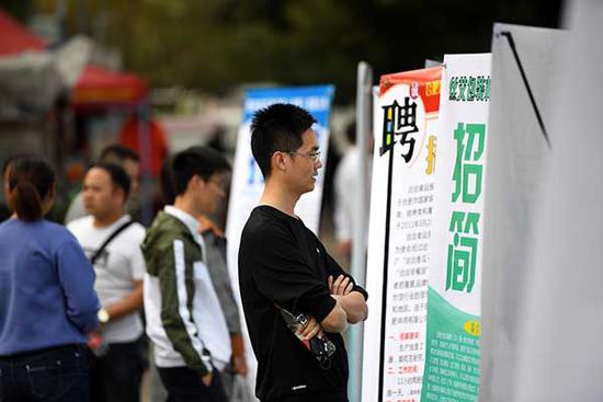 11月16日，求职者在招聘会现场查看招聘信息。  新华社记者 刘军喜 摄