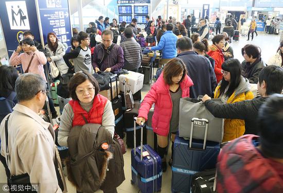 在大阪机场,准备登机的中国游客。(视觉中国)