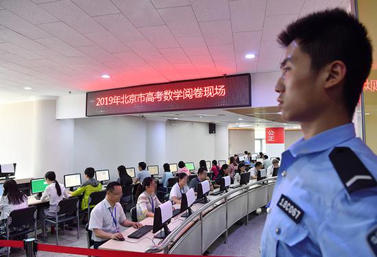 在安保人员值守下,2019北京高考数学阅卷工作正在进行。