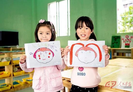 松桃苗族自治县蓼皋街道团山幼儿园，小朋友展示她们在幼儿园里画的绘画作品。