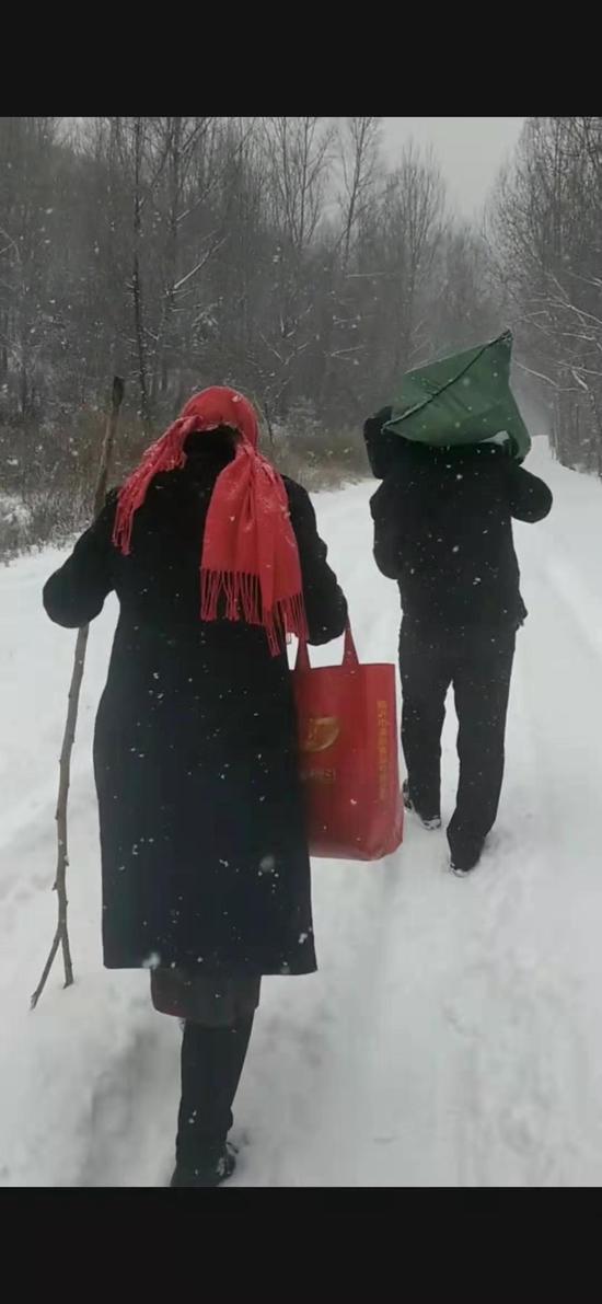 两位老师一前一后在雪地里行走。受访者供图