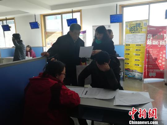 一位父亲替孩子参加招聘会。 孙婷婷 摄