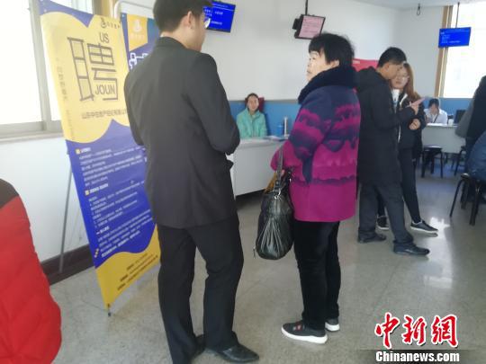 一位父母替孩子参加招聘会,咨询招聘人员相关问题。 孙婷婷 摄