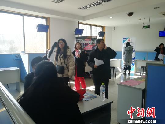 一位父亲带孩子来参加招聘会。 孙婷婷 摄