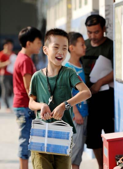 2013年9月1日，在河南省洛阳市西工区东下池小学，该市城市义务教育阶段学生拿到免费提供的教科书。视觉中国供图（本版均为资料图片）