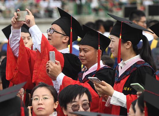 毕业生用手机记录毕业典礼。