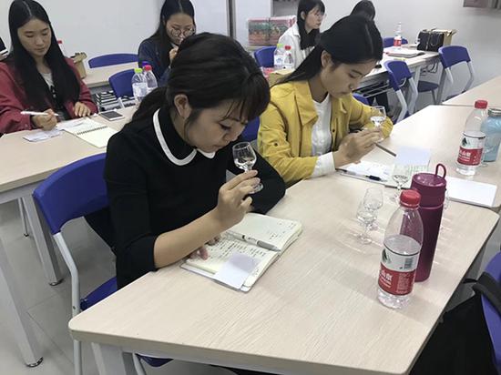 白酒学院学生学习“品酒”,并做笔记。
