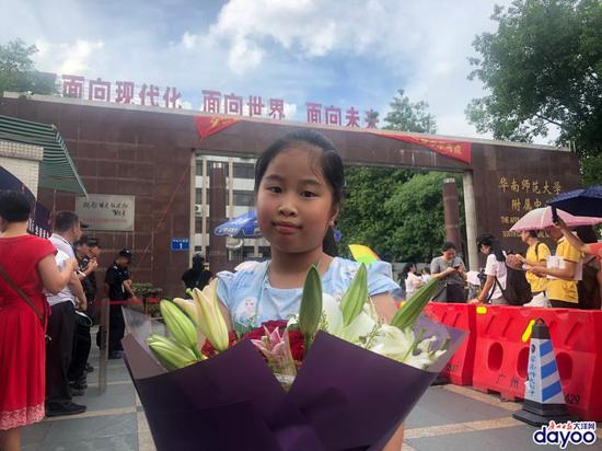 9岁的赖芊霖从深圳过来,她准备给哥哥送一束花,抱他一下,亲他一下,祝他金榜题名,高考成功。广报全媒体记者林霞虹摄