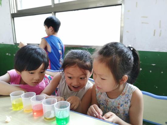 色彩接力实验课上,小朋友们早观察杯子中水颜色的变化,并表现出惊讶的表情。