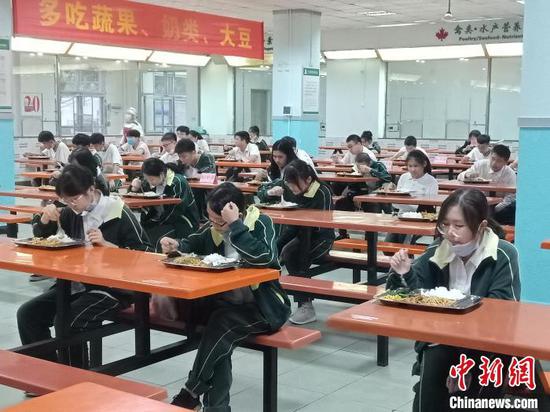 海南枫叶国际学校学生就餐相隔一米以上，实行专人专座，且只能单向就坐。　张茜翼 摄