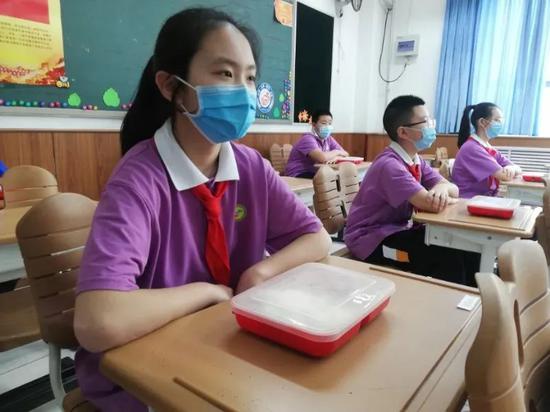 午饭时间到了,孩子们保持科学间隔,一人一餐盒,健康享用美味。