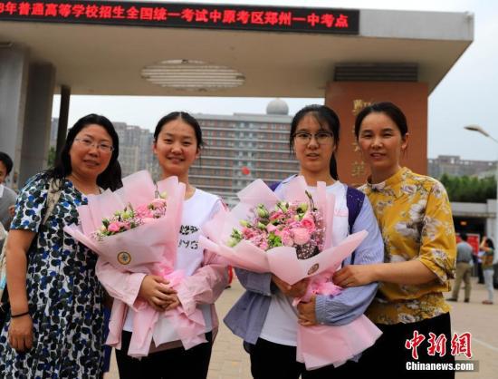 资料图：6月8日，河南郑州一高考考点外，家长向考生送上鲜花庆祝考试结束。当日，全国部分地区2018年高考结束。 中新社记者 王中举 摄