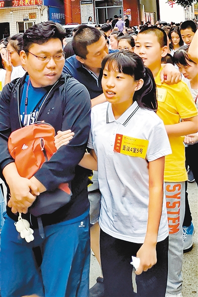 6月15日,西安益新中学门前,家长送孩子参加小升初面谈。 记者 李安定 摄