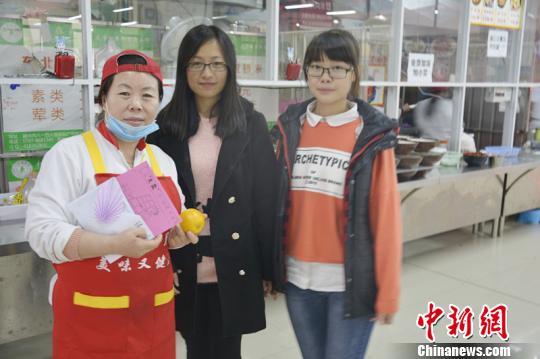 感恩节当天，江西理工大学的两名学子给食堂大妈送感恩节礼物。　汪东芳 摄